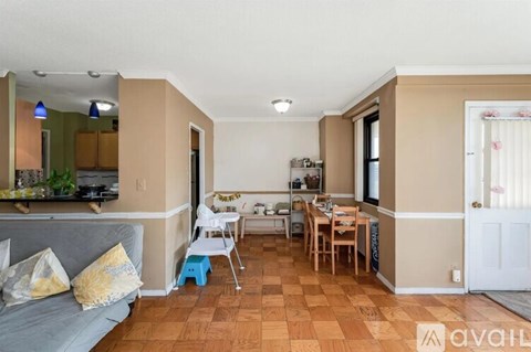 A living room with a grey couch and a wooden dining table.