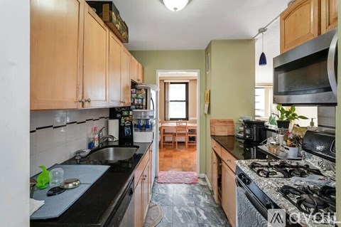 A kitchen with black countertops and wooden cabinets.