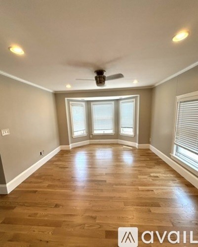 A room with wooden flooring and a ceiling fan.