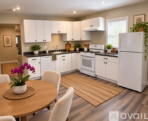 A kitchen with white cabinets and a wooden table.