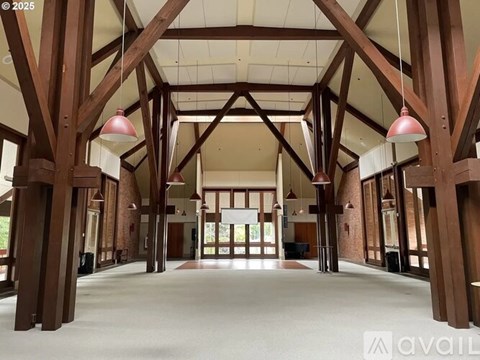 A large open space with wooden beams and hanging lights.