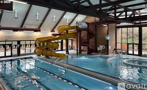 A large indoor swimming pool with a slide.