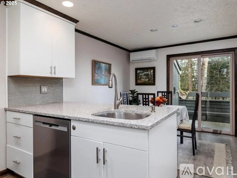 A kitchen with white cabinets and a granite countertop.