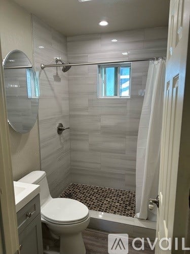 A white toilet in a small bathroom with a glass shower door.
