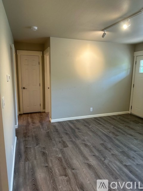 A room with wooden flooring and a door.