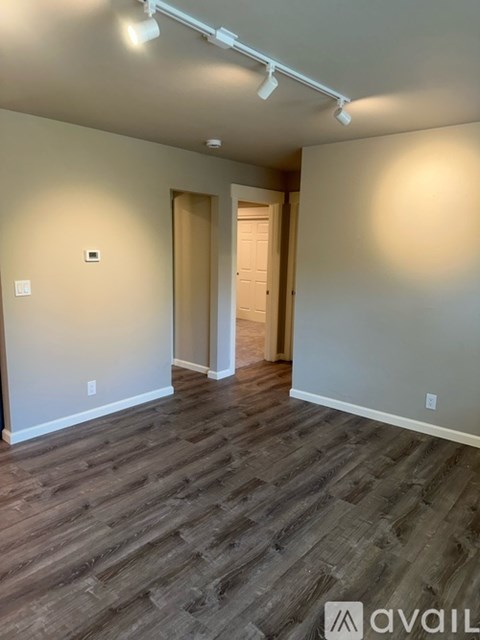 A room with wooden flooring and white walls.