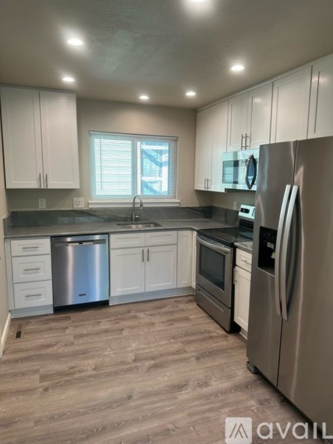 A kitchen with white cabinets and stainless steel appliances.