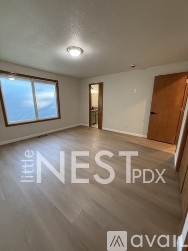 A spacious room with a window and a door is available for rent.