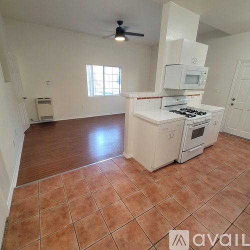 A kitchen with a stove, microwave, and oven.