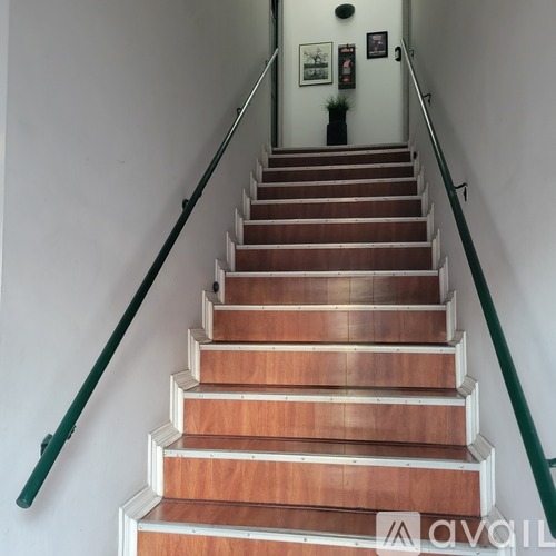 A staircase with wooden steps and green handrails.