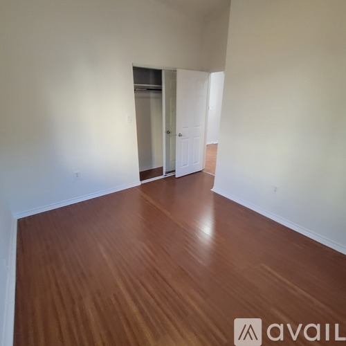 A hallway with wooden floors and white walls.