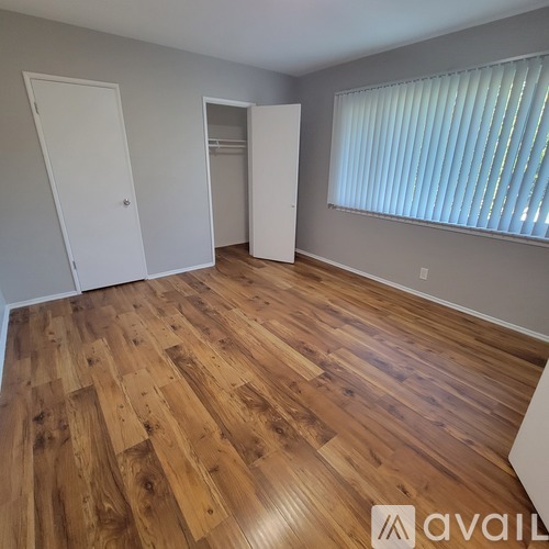 A room with wooden flooring and two white doors.