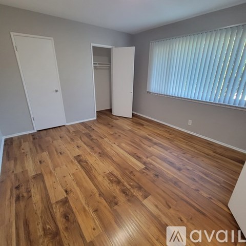 A room with wooden flooring and two white doors.