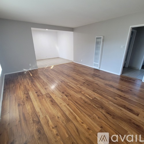 A room with wooden flooring and white walls.