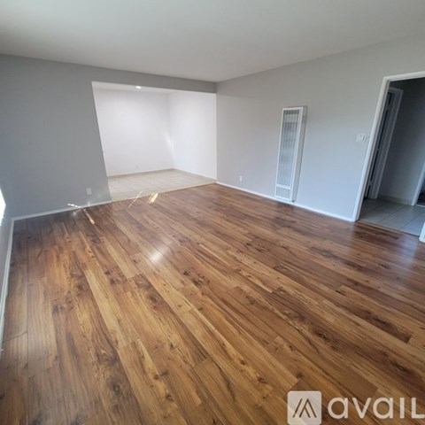 A room with wooden flooring and white walls.