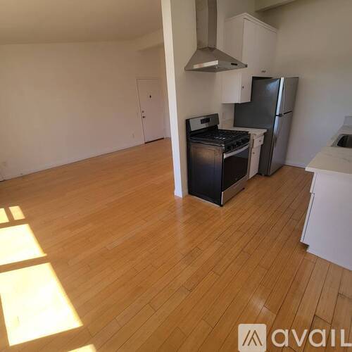 A kitchen with wooden floors and white walls.
