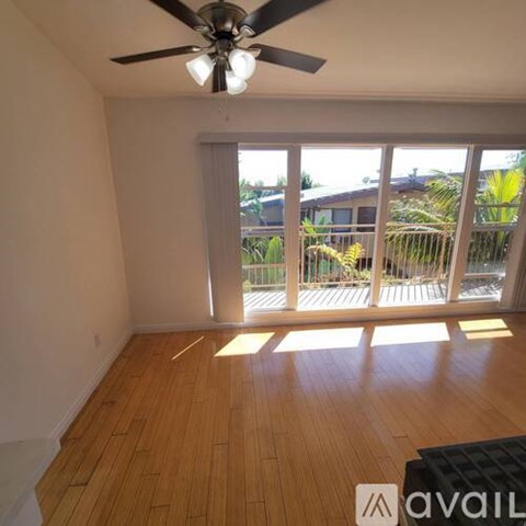 A room with wooden floors and a ceiling fan.
