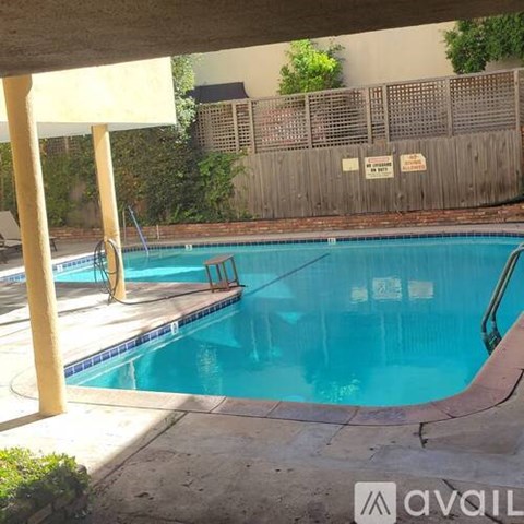 A pool with a ladder and a diving board.