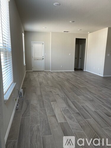 A hallway with a wooden floor and white walls.