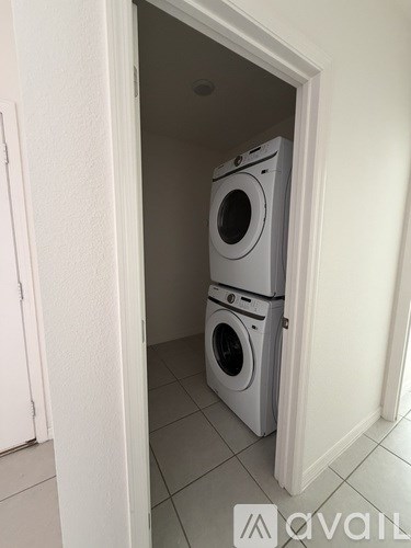 Two washing machines are stacked in a small space.