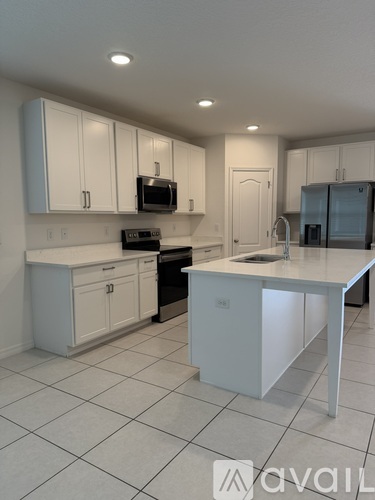 A kitchen with white cabinets and appliances.