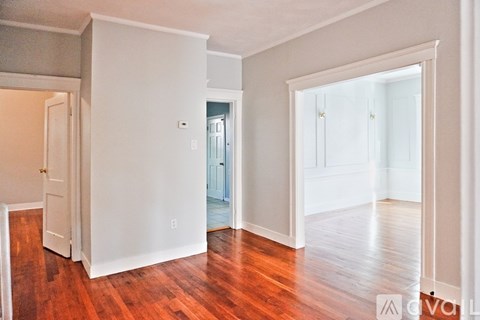 A living room with hardwood floors and white walls.