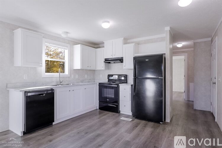 A kitchen with white cabinets and black appliances.