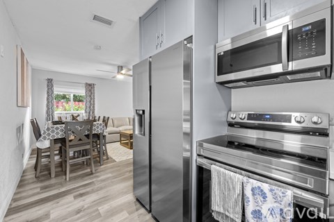 A kitchen with a dining table and chairs.