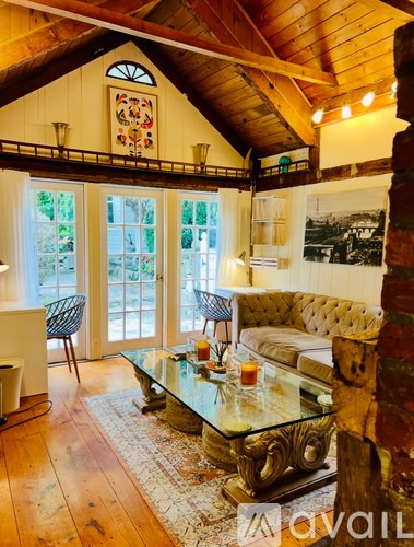 A living room with a glass coffee table and a couch.