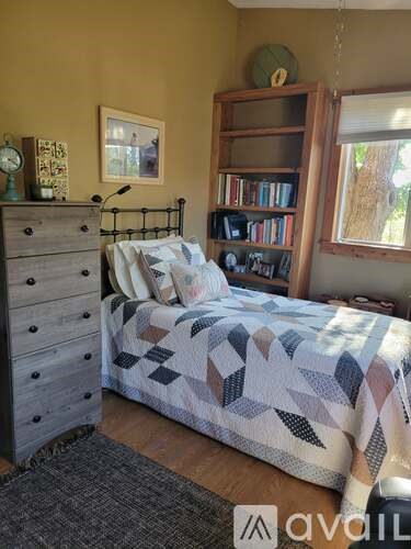 A bedroom with a bed, a dresser, and a bookshelf.