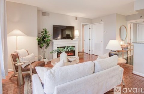 A living room with a white couch and a fireplace.