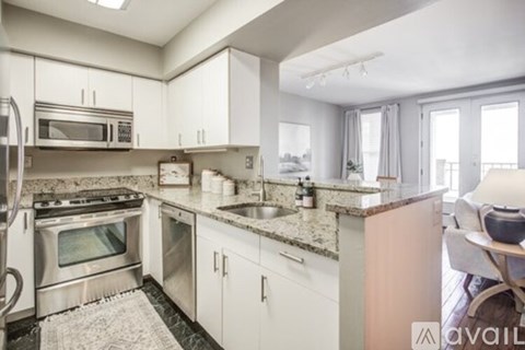 A kitchen with white cabinets and granite countertops.
