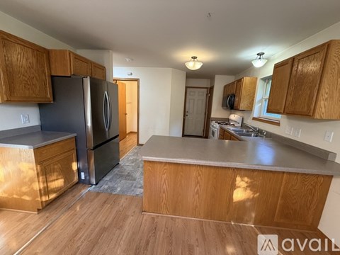 A kitchen with wooden cabinets and a black refrigerator.