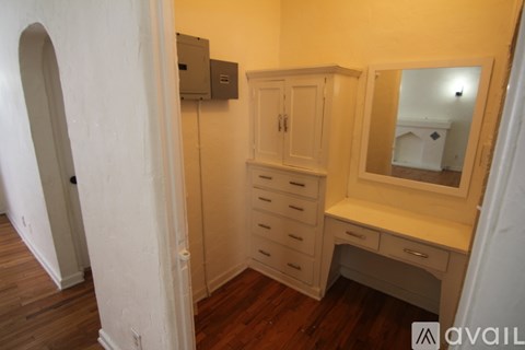 A small room with a desk and a mirror.