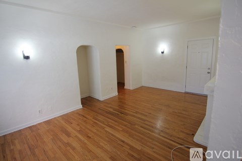A room with wooden flooring and white walls.