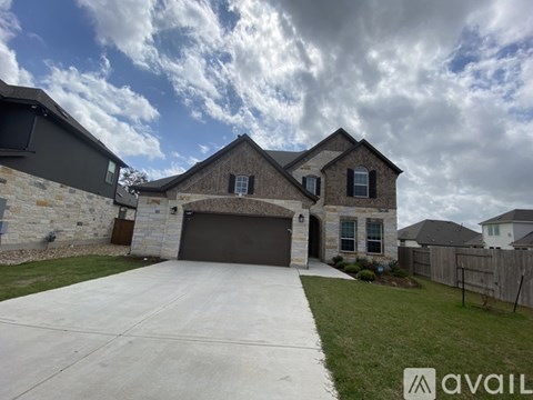 A house with a stone wall and a garage door.
