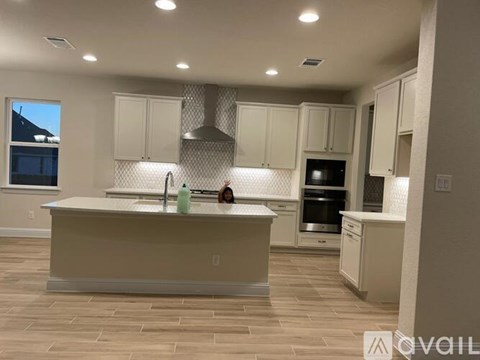 A kitchen with a large island and a window.