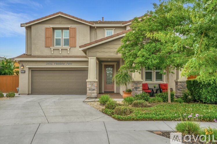 A house with a garage and a driveway in front of it.