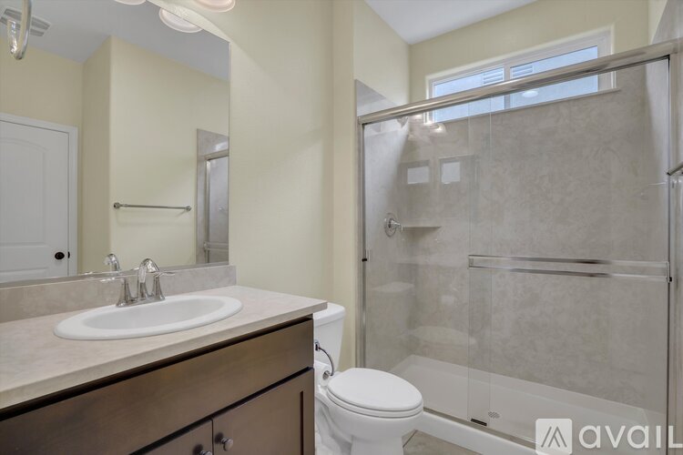 A bathroom with a toilet, sink, and walk-in shower.