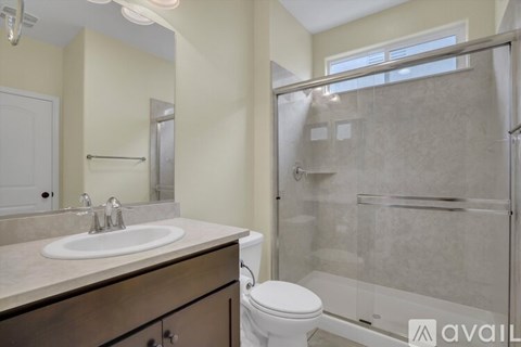 A bathroom with a toilet, sink, and walk-in shower.