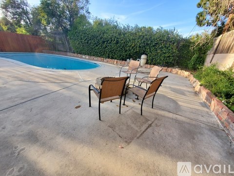 A pool with a table and chairs in front of it.
