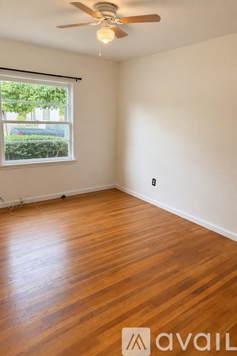 A room with wooden floors and a ceiling fan.