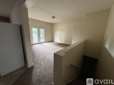 A carpeted room with a door leading outside.