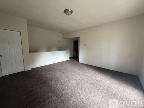 A room with white walls and carpeted floor.