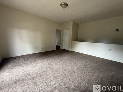 A room with a carpeted floor and a doorway leading to another room.