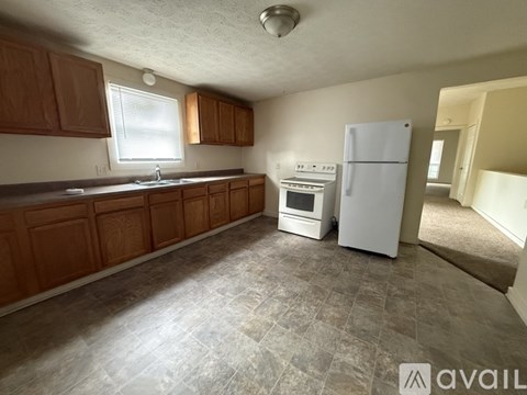 A kitchen with wooden cabinets and a white refrigerator.