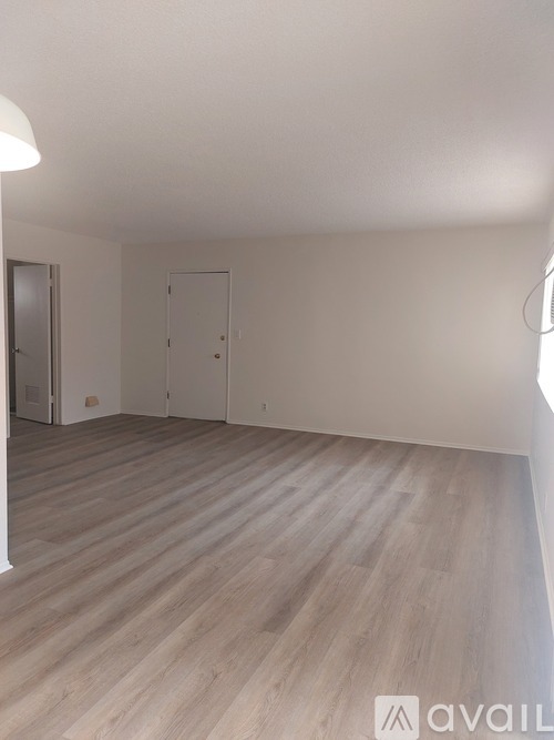 A room with wooden flooring and two doors.
