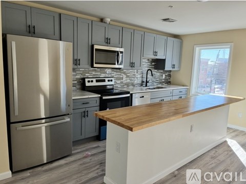 A kitchen with a refrigerator, microwave, oven, and cabinets.