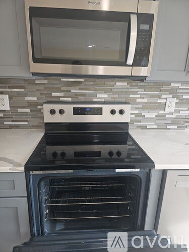 A modern kitchen with a stainless steel oven and microwave above it.
