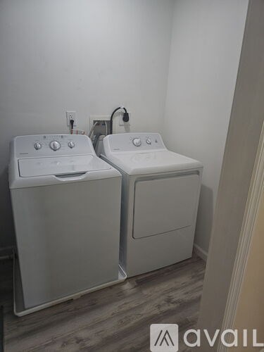 Two white washing machines in a small room.